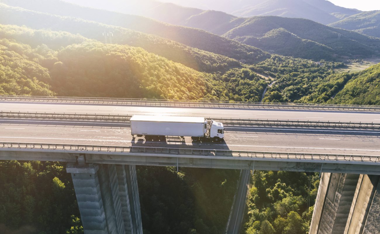 camiones-carretera-montana-al-atardecer-1-scaled.jpg