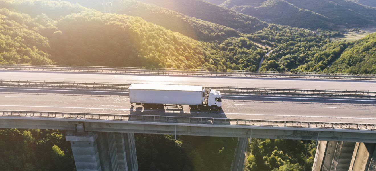 camiones-carretera-montana-al-atardecer-1-scaled.jpg