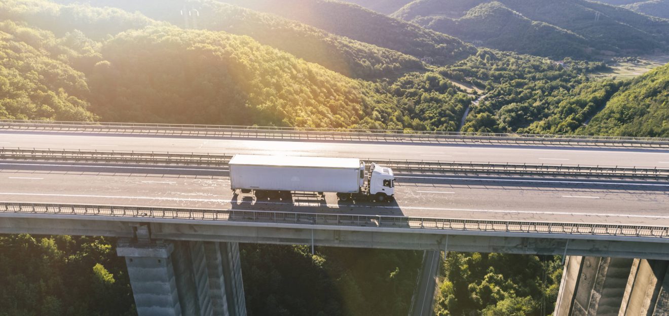 camiones-carretera-montana-al-atardecer-1-scaled.jpg