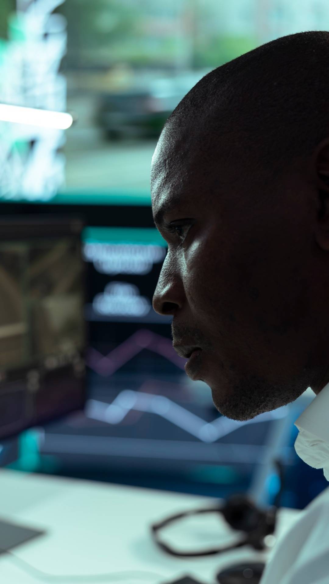 African american employee monitoring traffic and locating truck driver